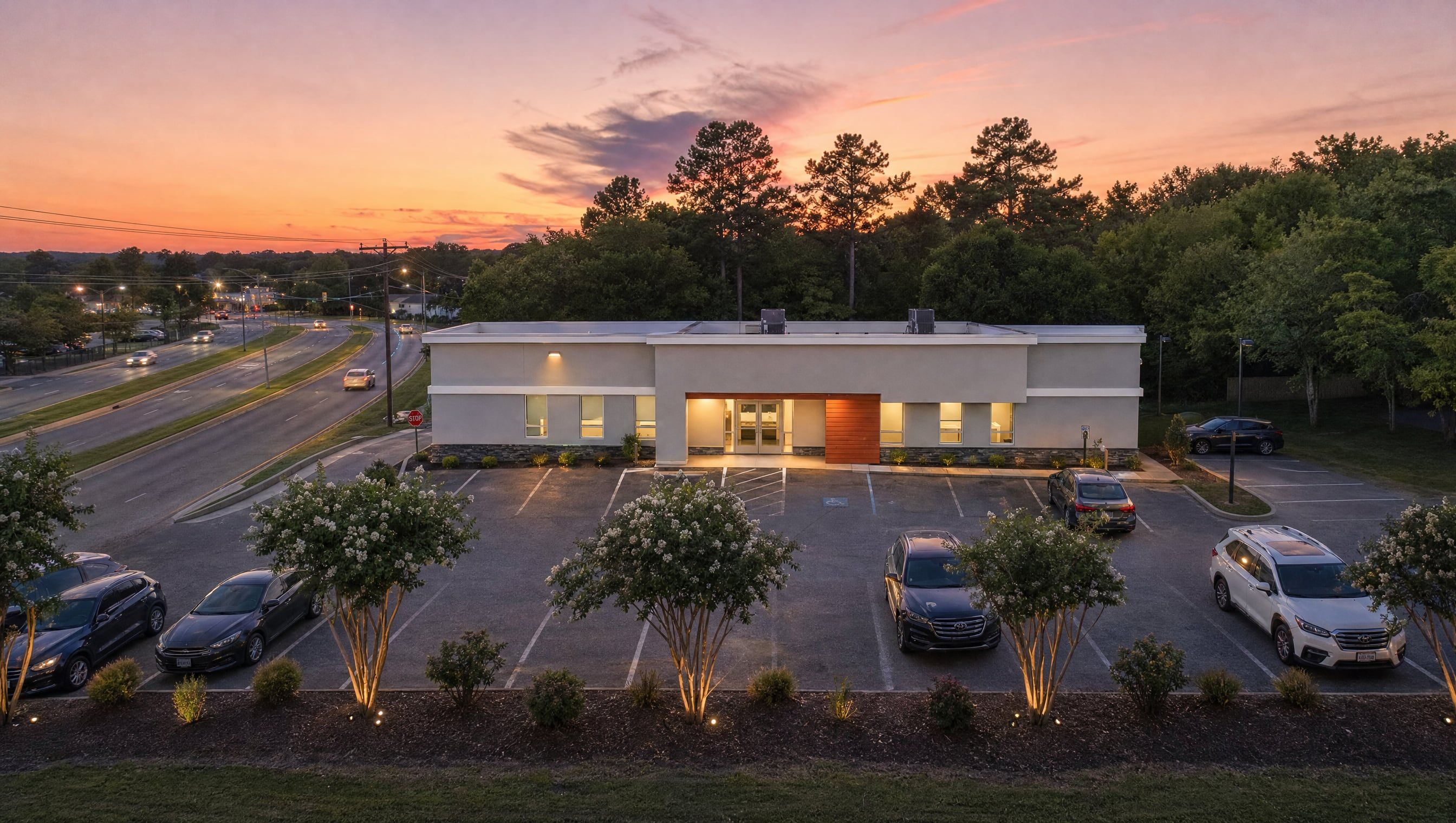Aerial rendering at sunset of the practice's single-story office on Patterson Avenue, with its parking lot and the trees around it