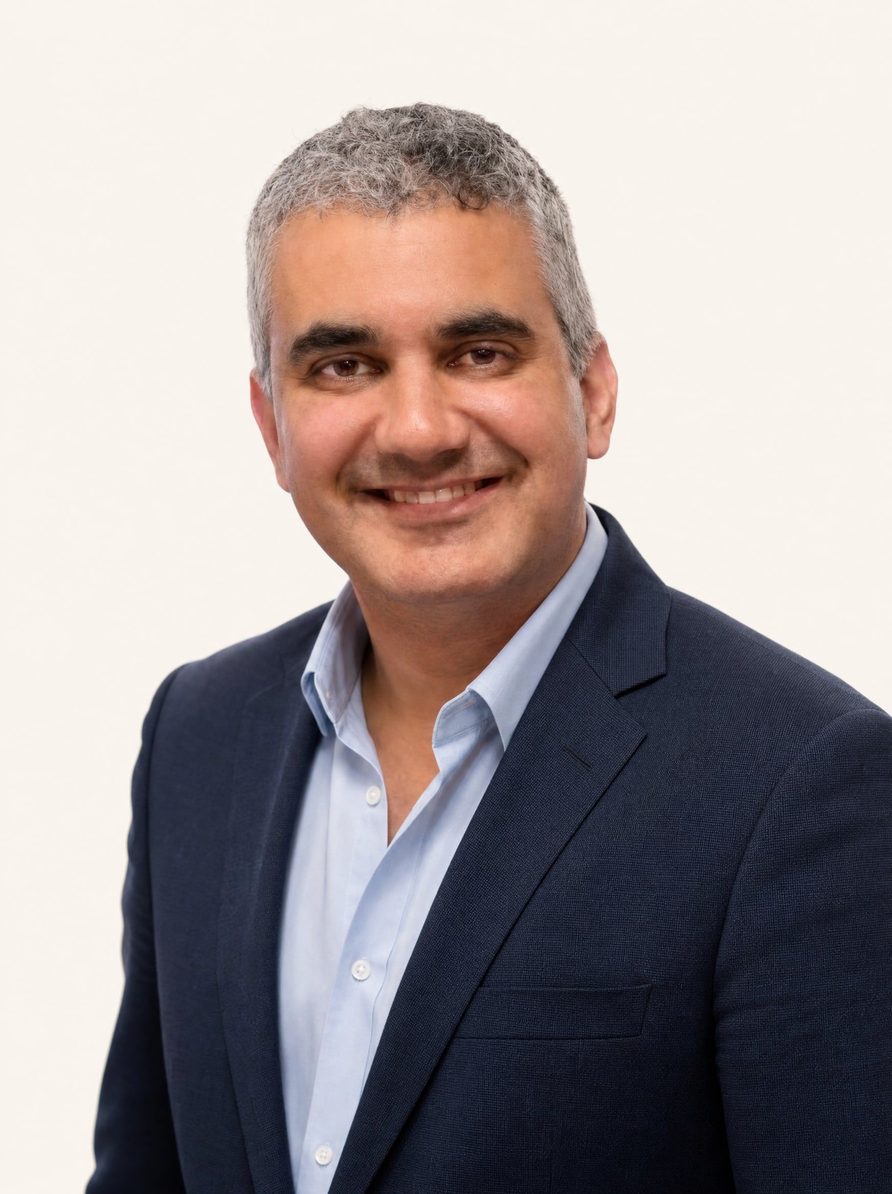 Dr. Paul Y. Da Cunha, smiling, in a navy blazer and light blue shirt